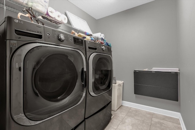 washroom featuring light tile patterned flooring and washing machine and clothes dryer