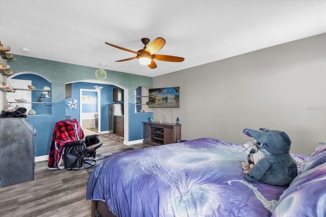 bedroom with ensuite bath, ceiling fan, and hardwood / wood-style floors