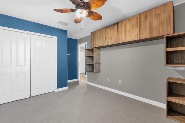 unfurnished bedroom with ceiling fan, a closet, and carpet floors