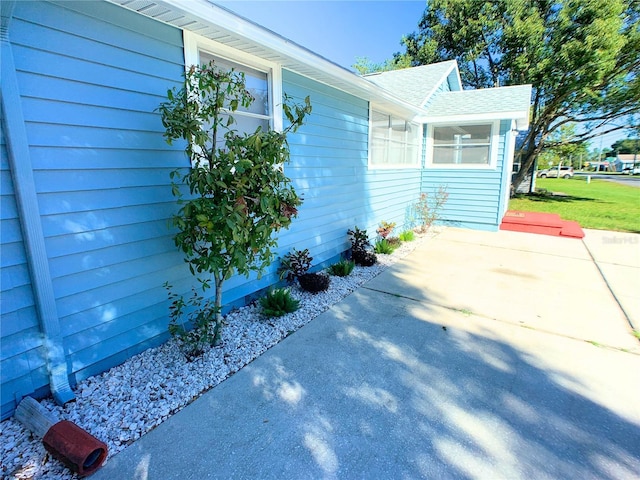 view of side of property featuring a lawn and a patio area