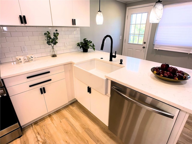 kitchen with white cabinetry, sink, hanging light fixtures, stainless steel dishwasher, and light wood-type flooring