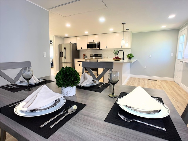 living room featuring sink and light hardwood / wood-style flooring