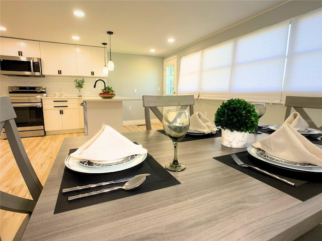 dining room featuring light wood-type flooring and sink