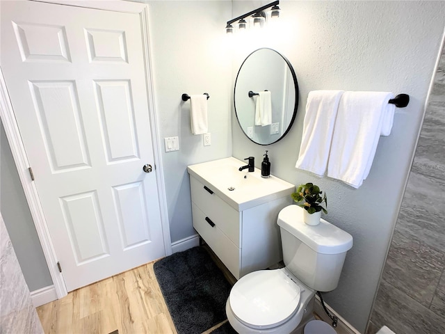 bathroom with hardwood / wood-style floors, vanity, and toilet