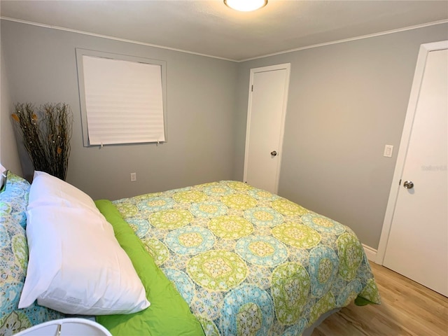 bedroom featuring light hardwood / wood-style floors and ornamental molding