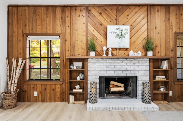 living room featuring hardwood / wood-style floors, wood walls, and a fireplace