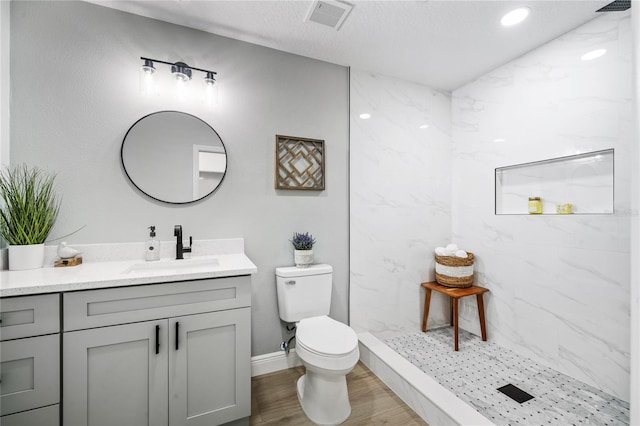 bathroom with toilet, wood-type flooring, walk in shower, and vanity