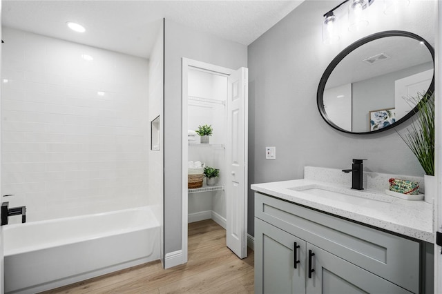 bathroom featuring vanity, hardwood / wood-style flooring, and bathtub / shower combination