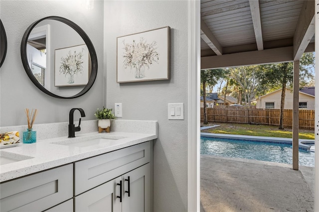 bathroom featuring vanity, wood ceiling, concrete flooring, and beamed ceiling