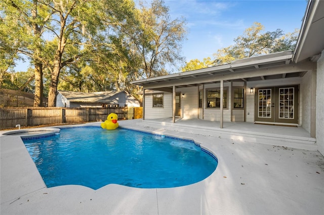 view of swimming pool with french doors and a patio