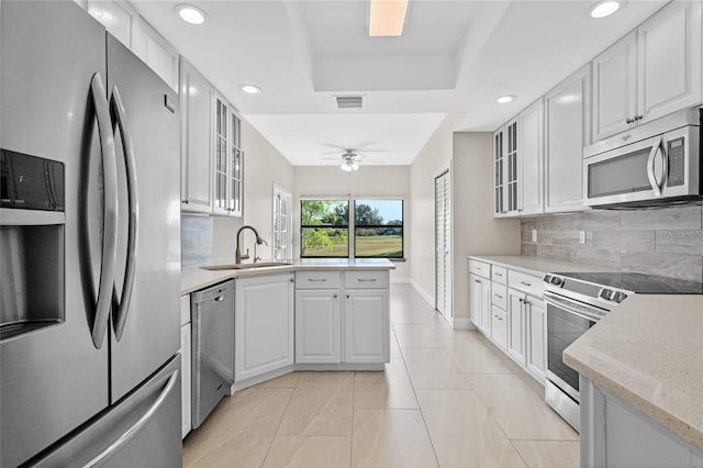 kitchen featuring white cabinets, ceiling fan, decorative backsplash, and appliances with stainless steel finishes