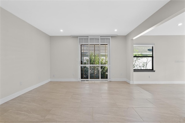 tiled empty room featuring plenty of natural light