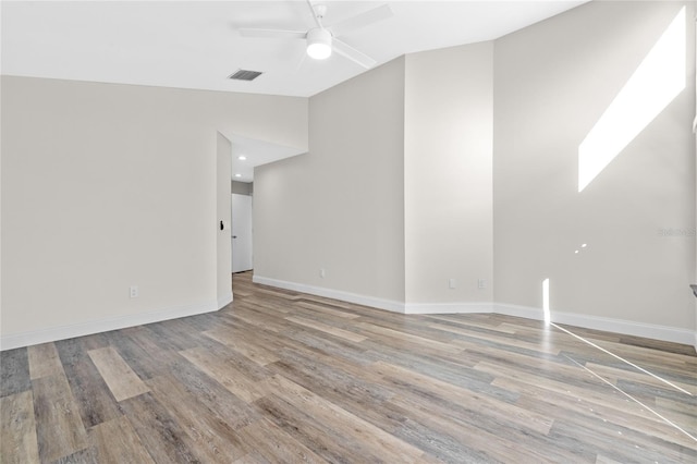 empty room featuring ceiling fan, wood-type flooring, and lofted ceiling