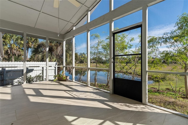 unfurnished sunroom featuring a wealth of natural light, a water view, and ceiling fan