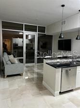 kitchen featuring white cabinetry, dishwasher, and decorative light fixtures