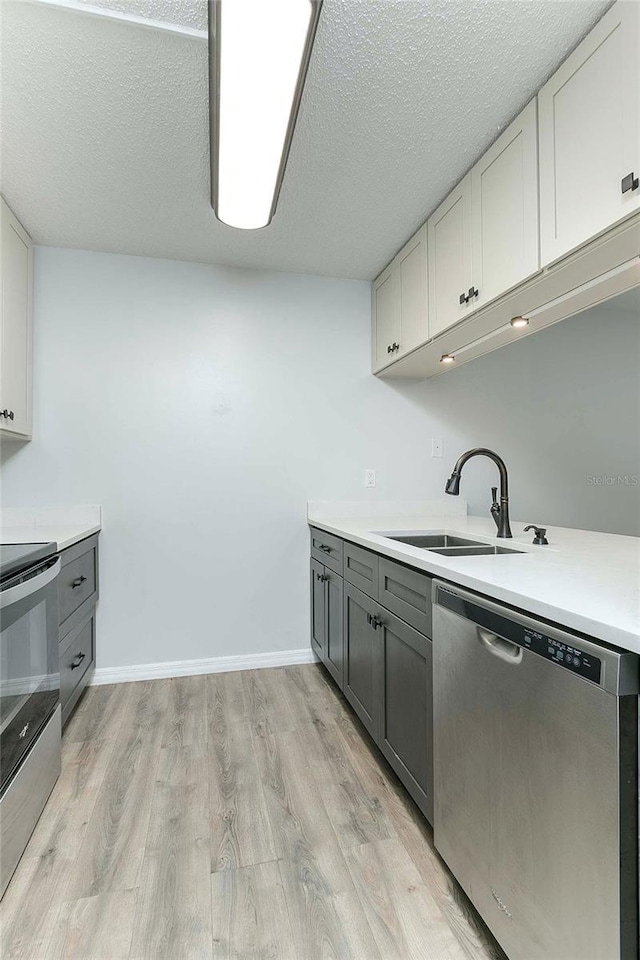 kitchen with white cabinets, sink, appliances with stainless steel finishes, and a textured ceiling