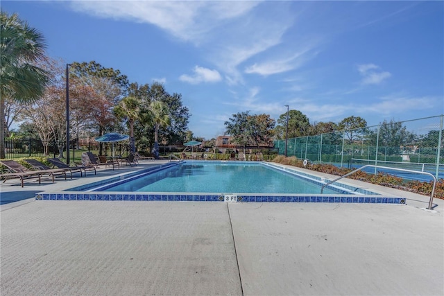 view of pool with tennis court