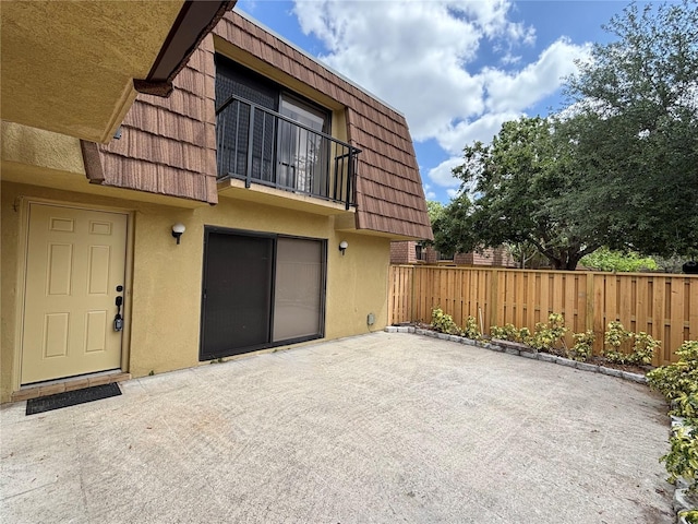 5341 Bamboo Ct Unit 418, Orlando, FL 32811 - exterior space featuring fence, stucco siding, a patio area, a balcony, and mansard roof