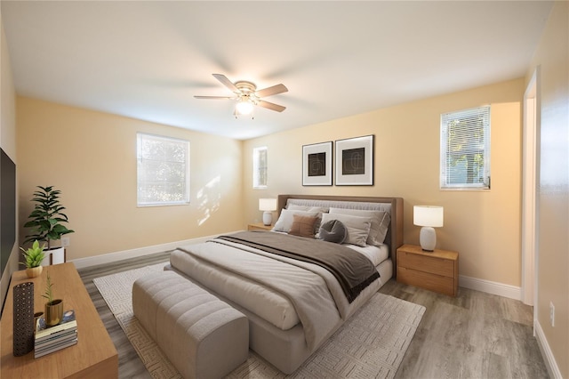 bedroom with multiple windows, ceiling fan, and light wood-type flooring