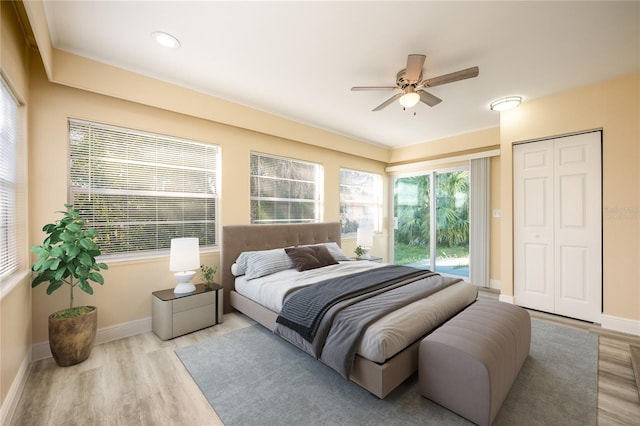 bedroom featuring ceiling fan, light wood-type flooring, access to outside, and a closet