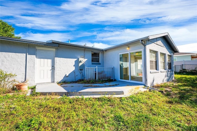 rear view of property featuring a lawn