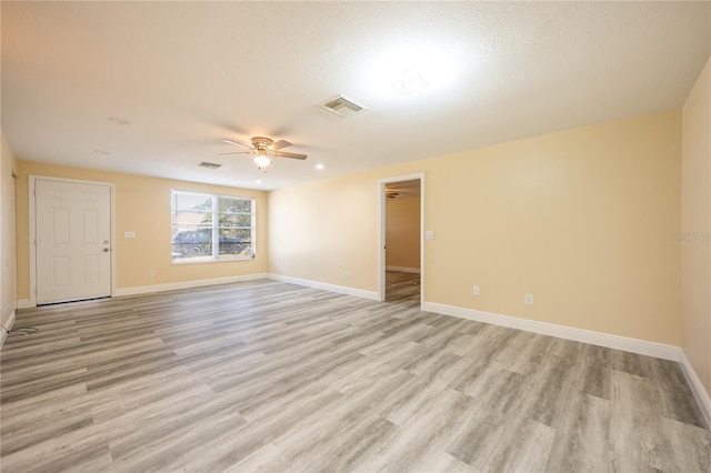 spare room with light hardwood / wood-style floors, ceiling fan, and a textured ceiling