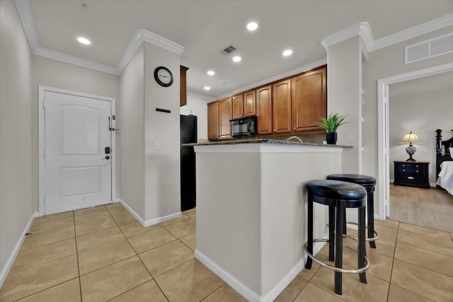 kitchen featuring a kitchen breakfast bar, kitchen peninsula, ornamental molding, and light tile patterned floors