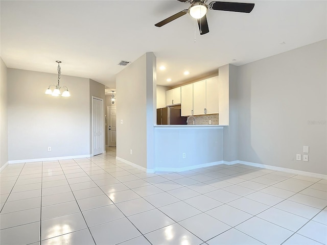 tiled empty room featuring sink and ceiling fan with notable chandelier