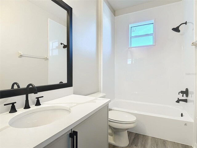 full bathroom featuring shower / bath combination, vanity, hardwood / wood-style flooring, and toilet