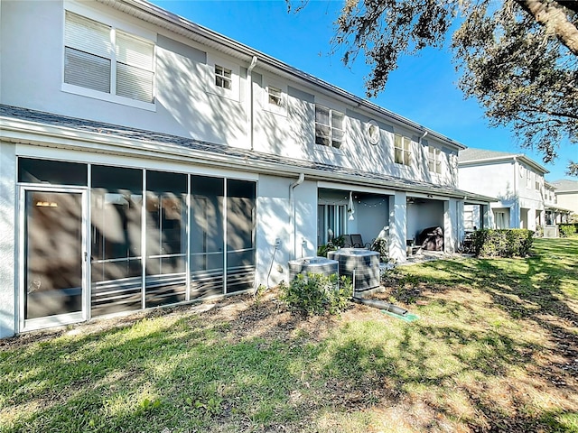 rear view of property featuring cooling unit and a yard