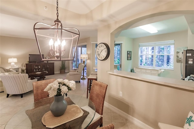 tiled dining area featuring an inviting chandelier