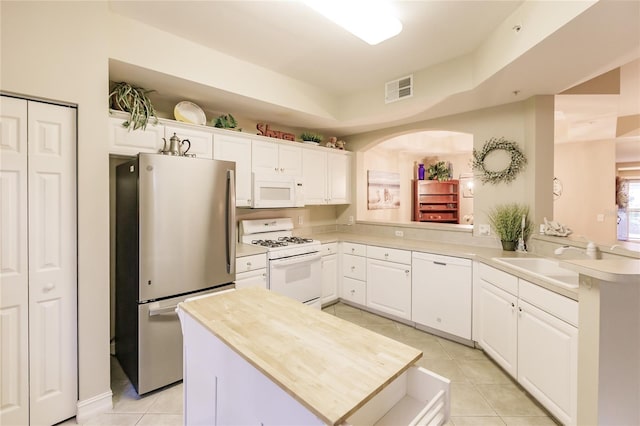 kitchen with white cabinetry, sink, white appliances, and kitchen peninsula