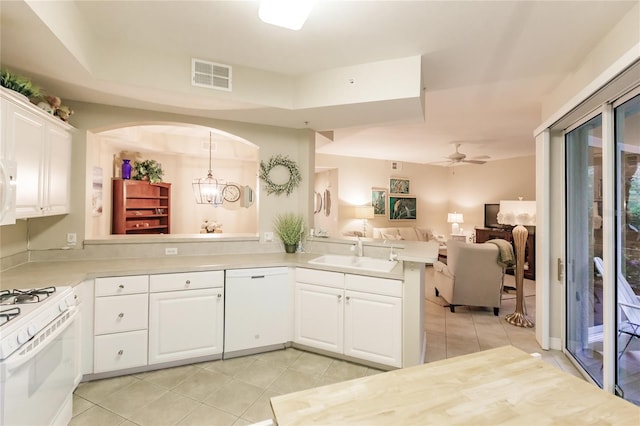 kitchen featuring decorative light fixtures, sink, white cabinets, kitchen peninsula, and white appliances