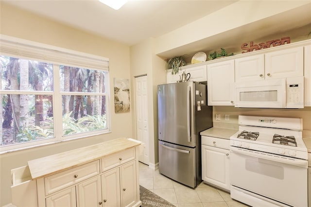 kitchen featuring light tile patterned flooring, white appliances, butcher block counters, and white cabinets