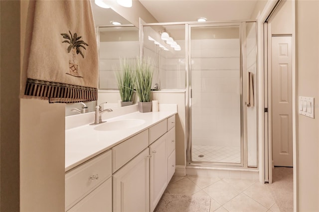 bathroom featuring vanity, a shower with shower door, and tile patterned floors