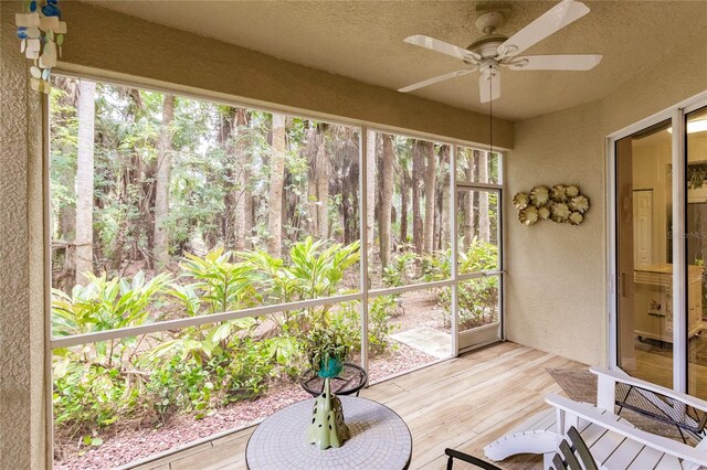 unfurnished sunroom featuring ceiling fan