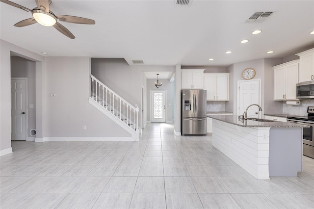 kitchen featuring sink, an island with sink, backsplash, and appliances with stainless steel finishes