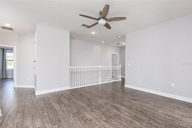 spare room with ceiling fan, dark wood-type flooring, and a textured ceiling