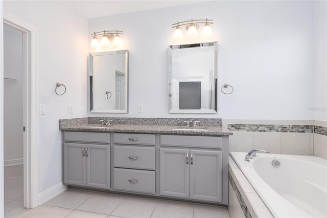 bathroom featuring vanity, tiled tub, and tile patterned flooring