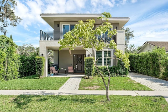 contemporary house with a porch, a balcony, and a front lawn