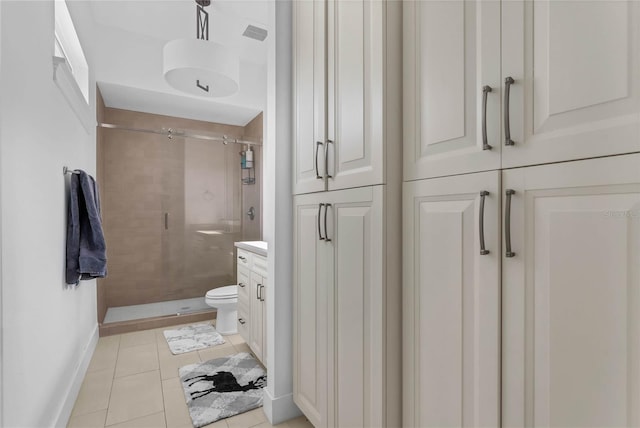 bathroom with tile patterned floors, vanity, toilet, and a shower with door