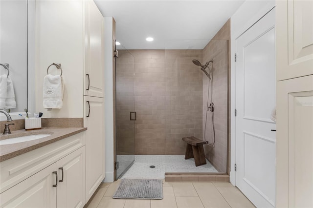 bathroom featuring tile patterned flooring, vanity, and walk in shower