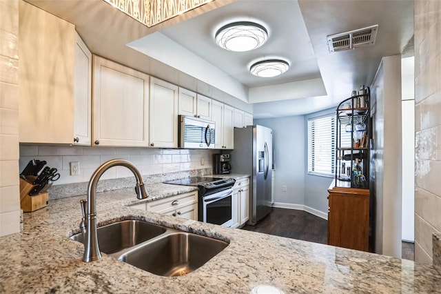 kitchen with visible vents, a sink, tasteful backsplash, appliances with stainless steel finishes, and a raised ceiling