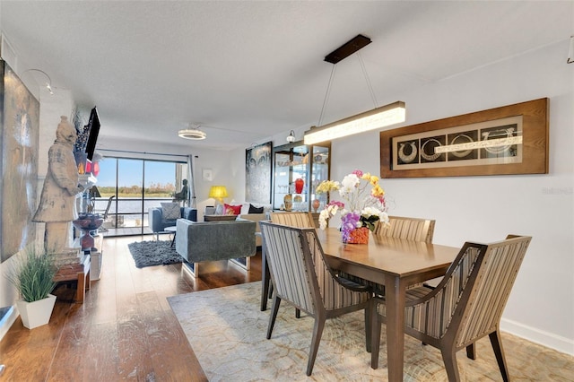 dining space with wood finished floors and baseboards