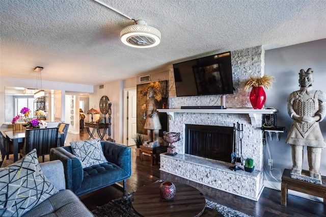 living room featuring hardwood / wood-style floors, a fireplace, and a textured ceiling