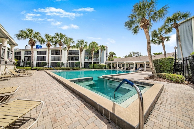 pool with a patio and fence