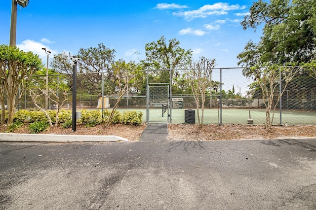 view of sport court with a gate and fence