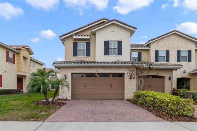 mediterranean / spanish-style house with a garage and a front lawn