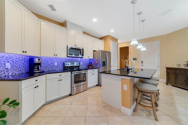 kitchen with sink, white cabinetry, a kitchen island with sink, and appliances with stainless steel finishes