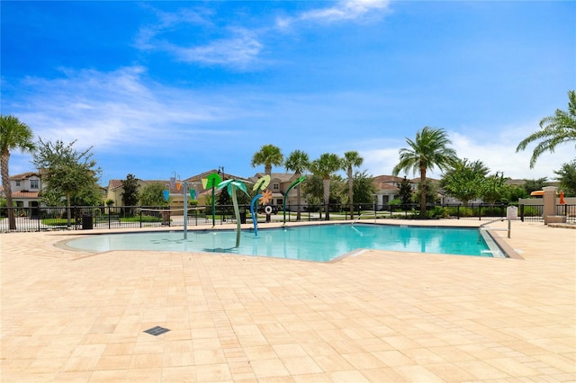 view of swimming pool with a patio area and a playground